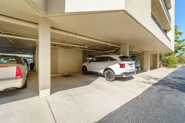 view of parking with a parking garage