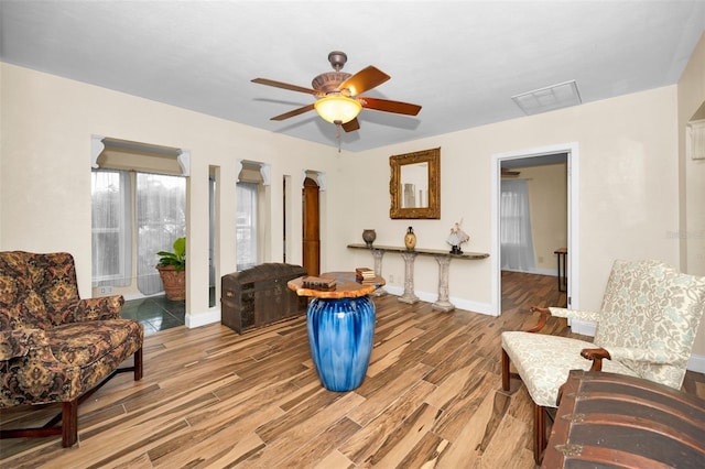 living area featuring wood-type flooring and ceiling fan