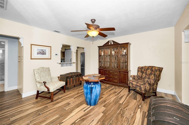 sitting room featuring wood-type flooring and ceiling fan