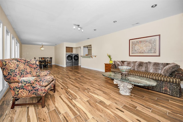 living room featuring light wood-type flooring and washer and clothes dryer