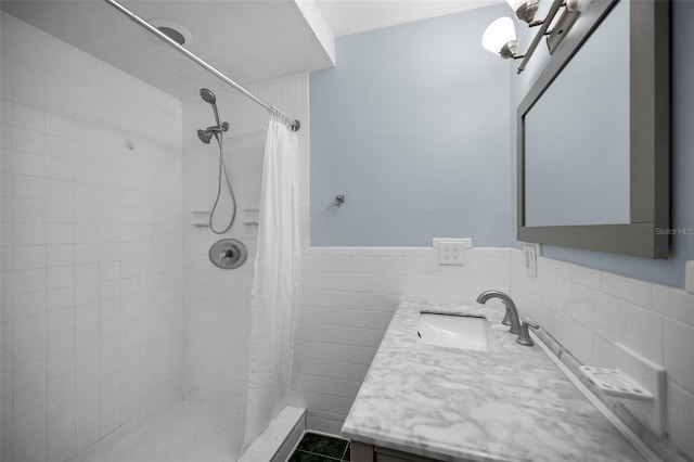 bathroom featuring tile patterned floors, vanity, curtained shower, and tile walls