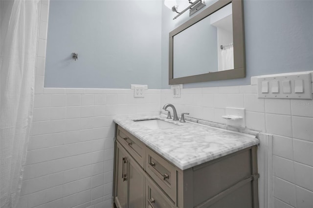 bathroom featuring vanity and tile walls