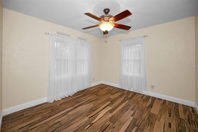 spare room featuring dark wood-type flooring and ceiling fan