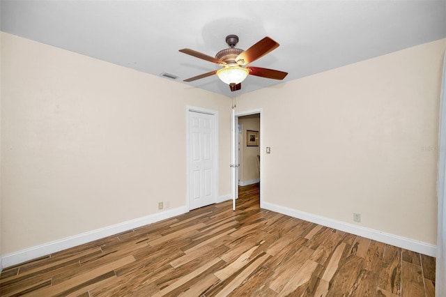 empty room with hardwood / wood-style floors and ceiling fan