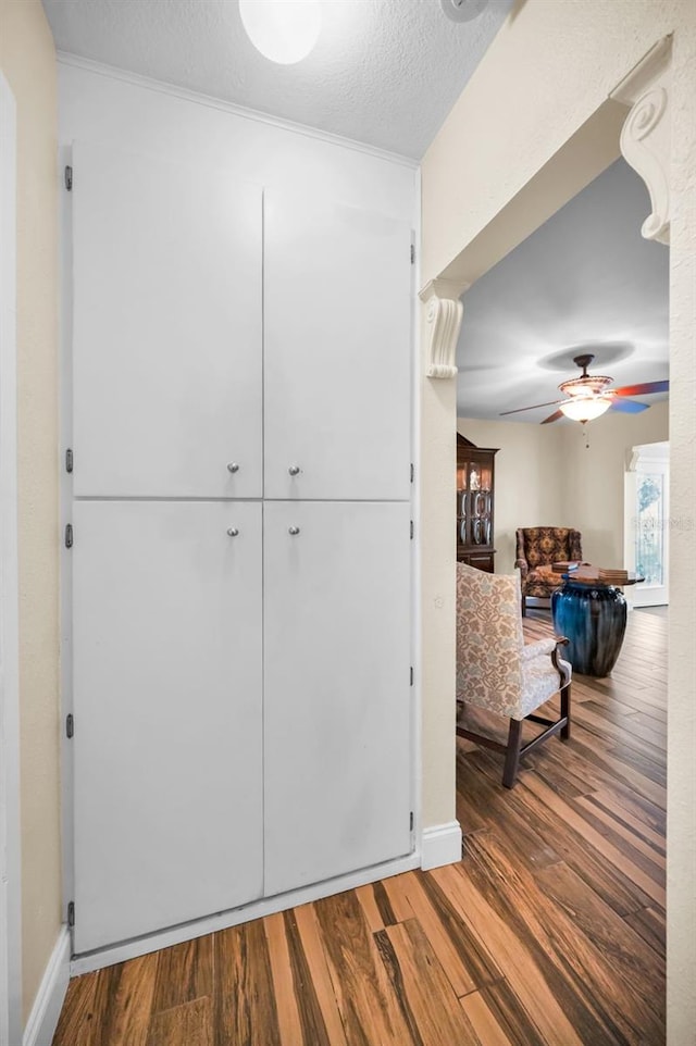 hall with hardwood / wood-style flooring and a textured ceiling