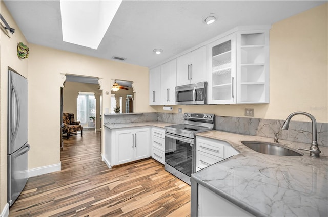 546 Orangewood Dr, Dunedin, FL 34698 - kitchen featuring appliances with stainless steel finishes, a sink, light wood-style flooring, and light stone counters