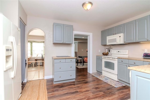 kitchen featuring gray cabinetry, white appliances, and dark hardwood / wood-style floors