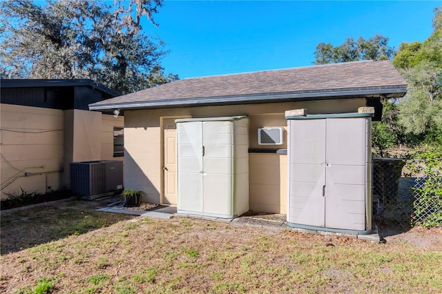 view of outbuilding with central AC unit and a lawn