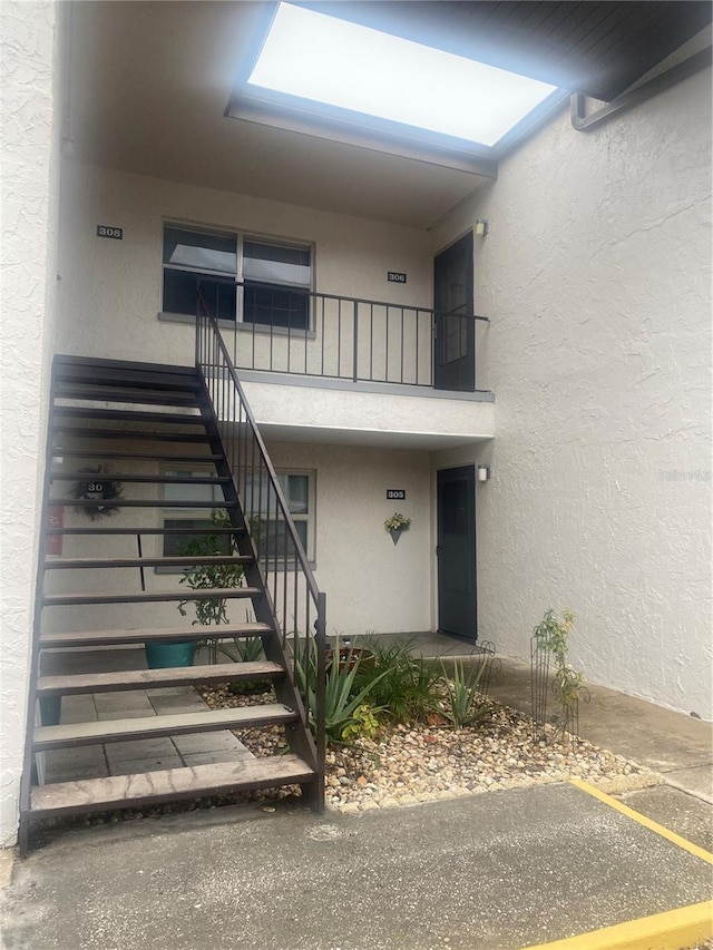 view of exterior entry featuring a balcony