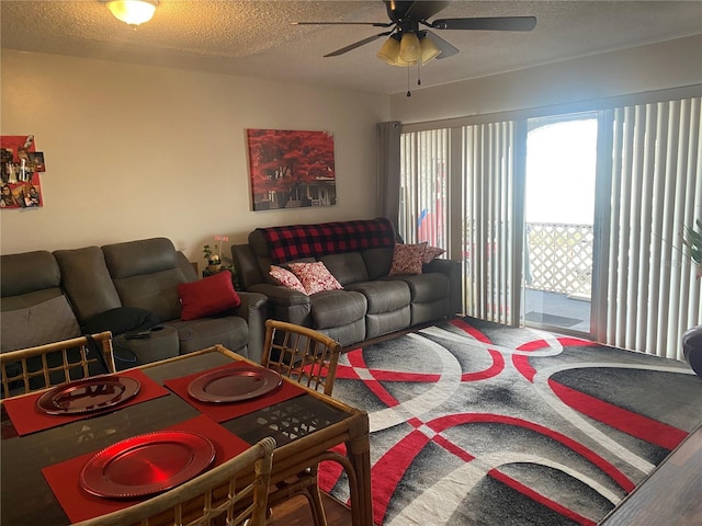 living room featuring ceiling fan and a textured ceiling