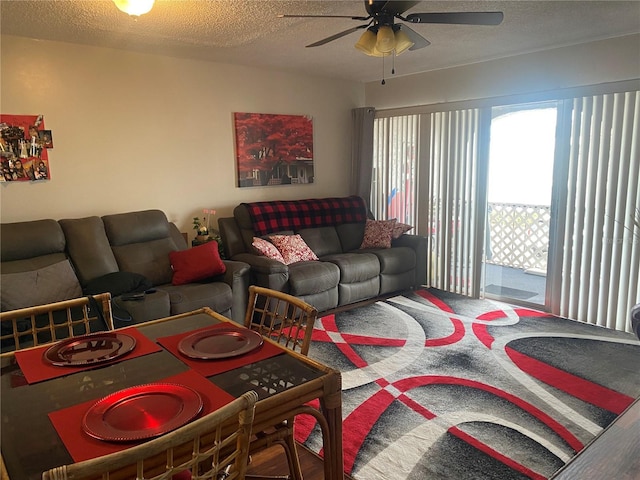 living room featuring ceiling fan and a textured ceiling