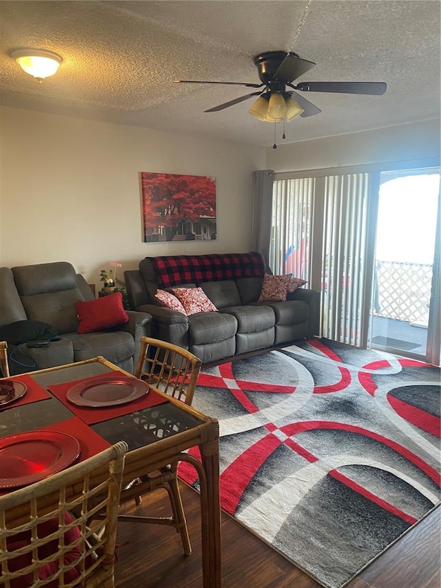 living room featuring ceiling fan, hardwood / wood-style flooring, and a textured ceiling