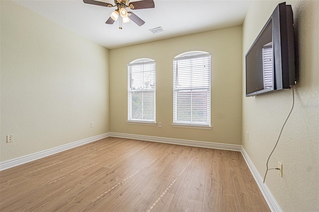 empty room with ceiling fan and light hardwood / wood-style flooring