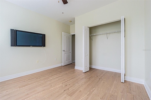 unfurnished bedroom featuring light hardwood / wood-style flooring, a closet, and ceiling fan