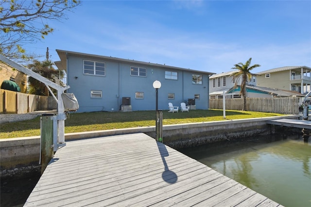 dock area featuring a lawn, central air condition unit, and a water view