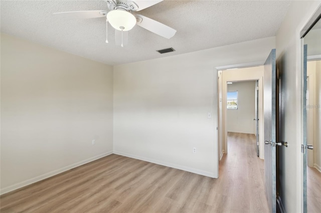 empty room featuring light wood-type flooring, a textured ceiling, and ceiling fan