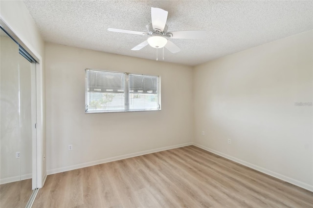 unfurnished bedroom featuring a closet, ceiling fan, a textured ceiling, and light wood-type flooring