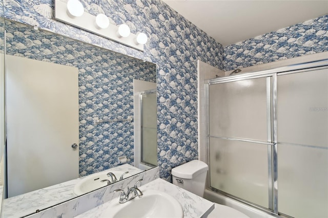 full bathroom featuring toilet, shower / bath combination with glass door, and vanity