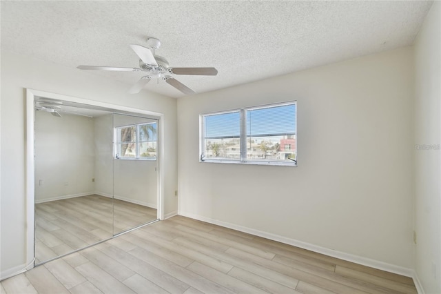 unfurnished bedroom with ceiling fan, a textured ceiling, and a closet