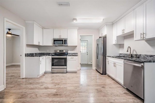 kitchen featuring white cabinetry, sink, light wood-type flooring, and appliances with stainless steel finishes