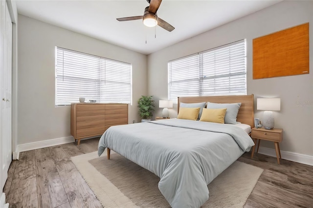 bedroom with ceiling fan, light hardwood / wood-style floors, and a closet