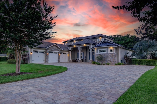 view of front of property featuring a garage and a lawn