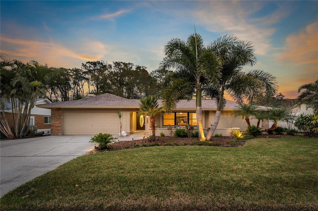 single story home featuring a yard and a garage