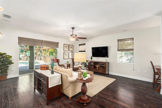 living room with dark wood-type flooring, plenty of natural light, and ceiling fan