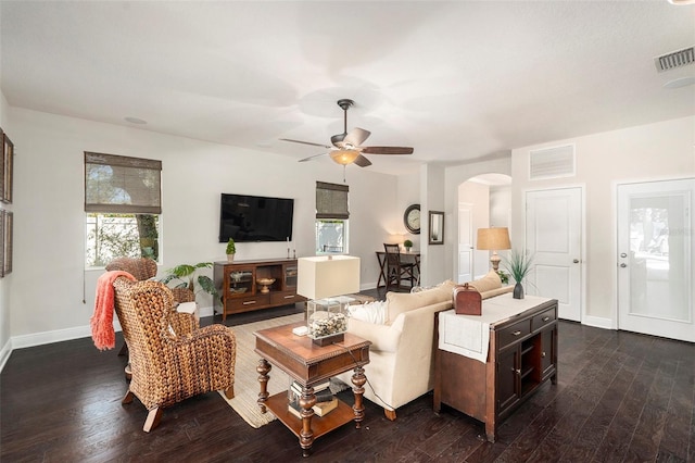 living room featuring ceiling fan and dark wood-type flooring