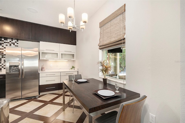 kitchen with decorative light fixtures, white cabinetry, stainless steel fridge with ice dispenser, and a notable chandelier