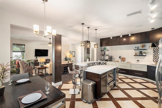 kitchen featuring dark brown cabinets, a center island, and hanging light fixtures