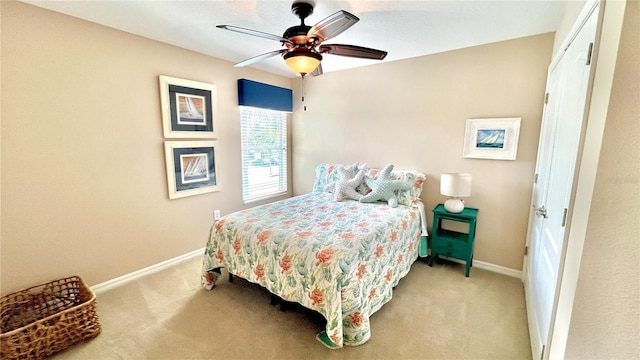 bedroom with ceiling fan, a closet, and light carpet