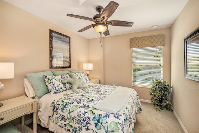 carpeted bedroom with ceiling fan and baseboards