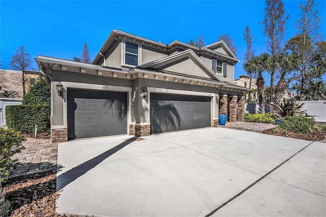 view of front of property with a garage, stone siding, driveway, and stucco siding