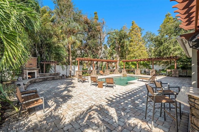 5701 S Macdill Ave, Tampa, FL 33611 - view of patio / terrace with an outdoor stone fireplace, a pergola, and an outdoor pool