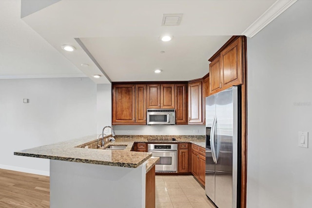 450 Knights Run Ave Unit 605, Tampa, FL 33602 - kitchen with sink, stainless steel appliances, light stone counters, a kitchen bar, and kitchen peninsula