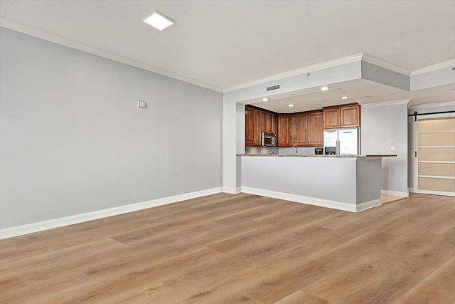 450 Knights Run Ave Unit 605, Tampa, FL 33602 - kitchen with stainless steel appliances, a barn door, light hardwood / wood-style flooring, and kitchen peninsula