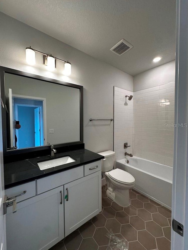 full bathroom featuring a textured ceiling, toilet, vanity, visible vents, and shower / washtub combination