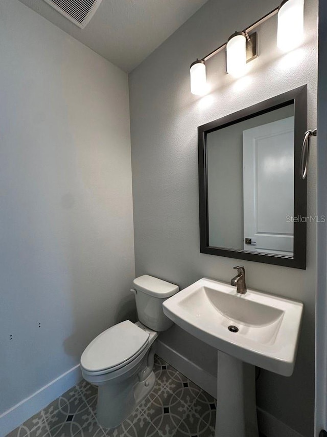 bathroom with tile patterned flooring, toilet, and baseboards