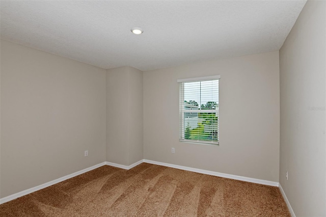 carpeted spare room with a textured ceiling