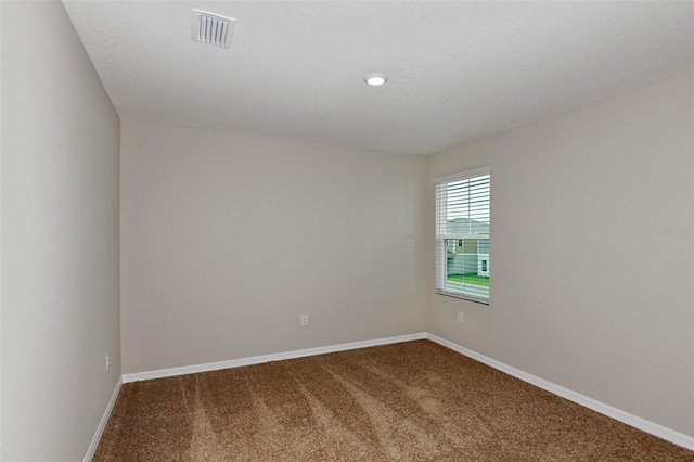 carpeted empty room with a textured ceiling