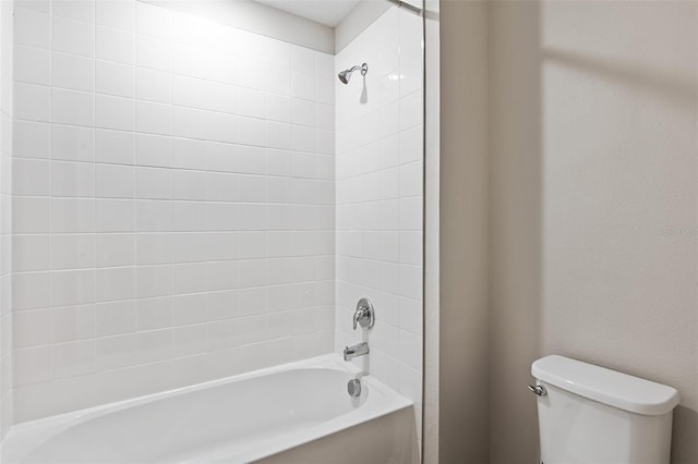 bathroom with toilet and tiled shower / bath