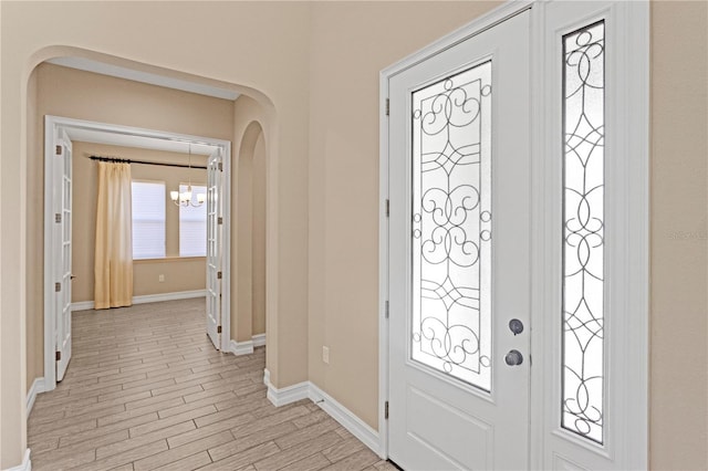 foyer with light hardwood / wood-style floors and a chandelier