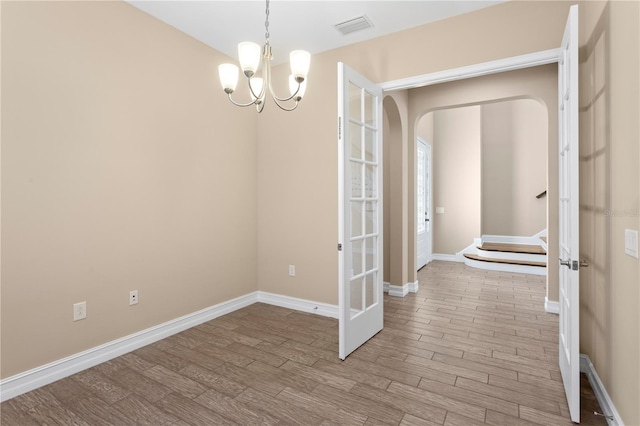 unfurnished dining area with light hardwood / wood-style flooring and a chandelier