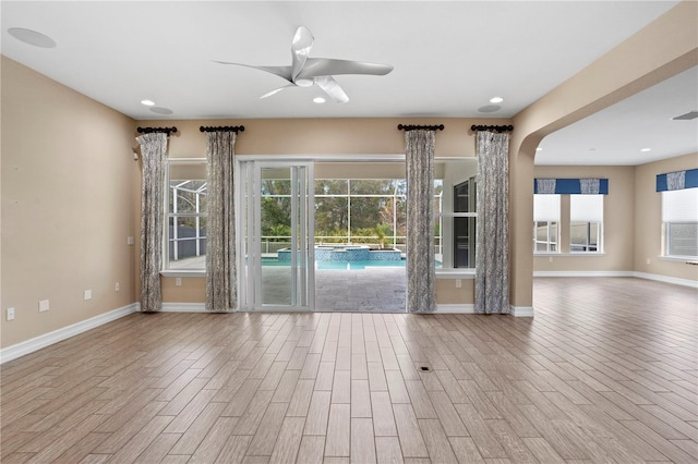 unfurnished living room with ceiling fan and light wood-type flooring