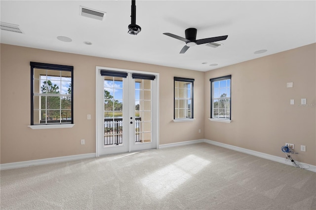 spare room with light colored carpet, french doors, and ceiling fan