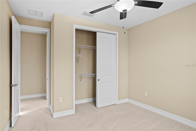 unfurnished bedroom featuring ceiling fan, a closet, and light carpet