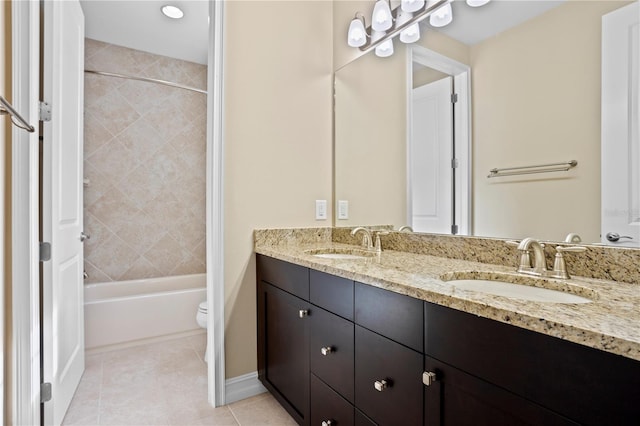 full bathroom with tile patterned flooring, vanity, tiled shower / bath, and toilet