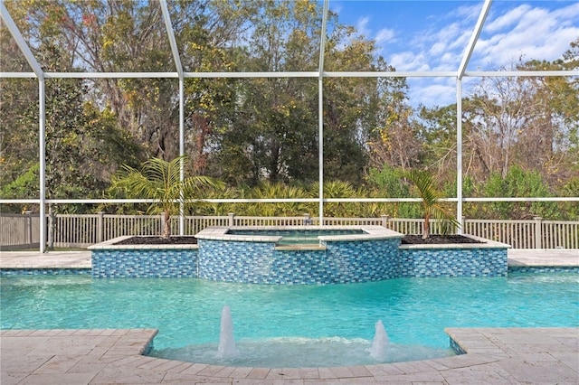 view of pool featuring an in ground hot tub, glass enclosure, and a patio area