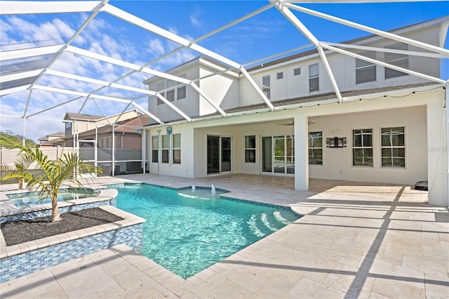 view of swimming pool with pool water feature, ceiling fan, a patio area, and glass enclosure